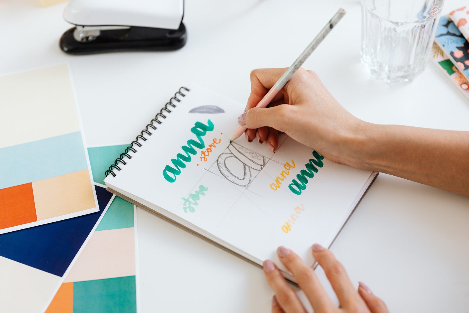 A person designs branding assets on a paper
pad