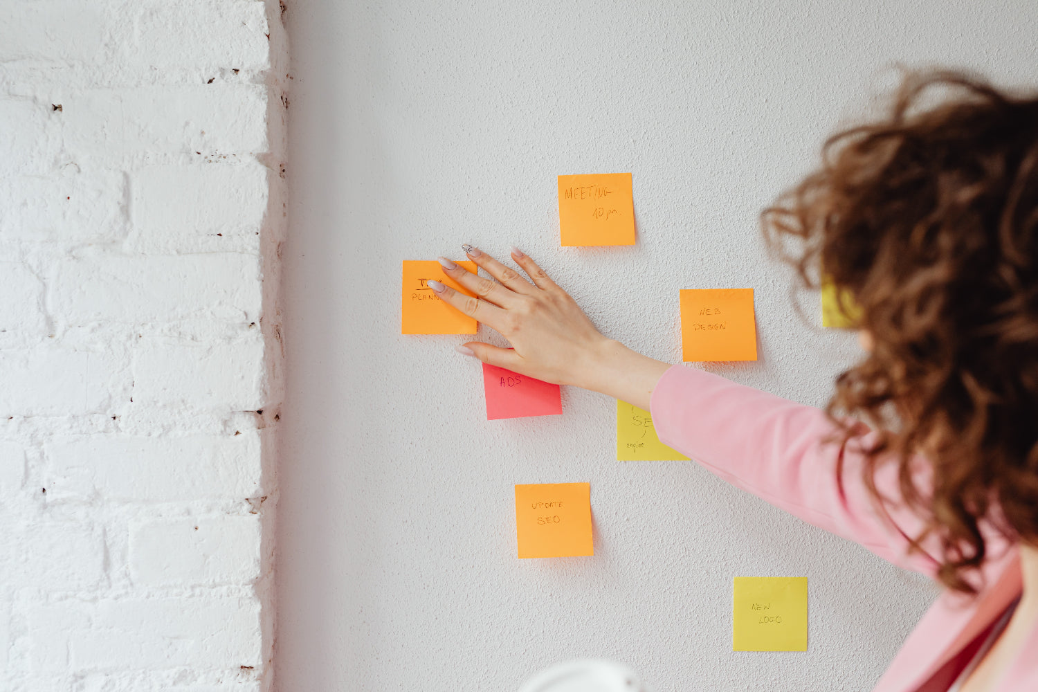 A woman organizes her business plan sections using sticky
notes