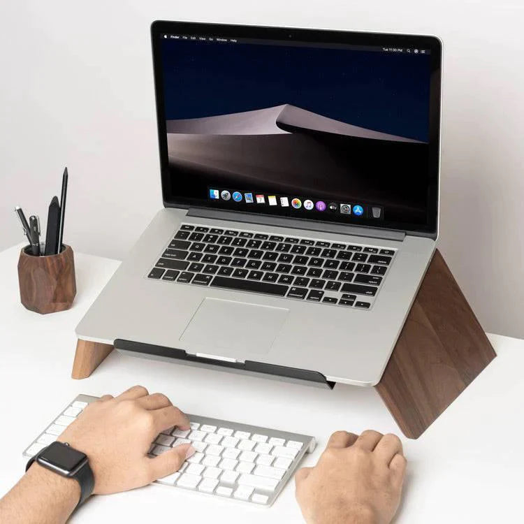 A wooden stand holds up a laptop on a
desk