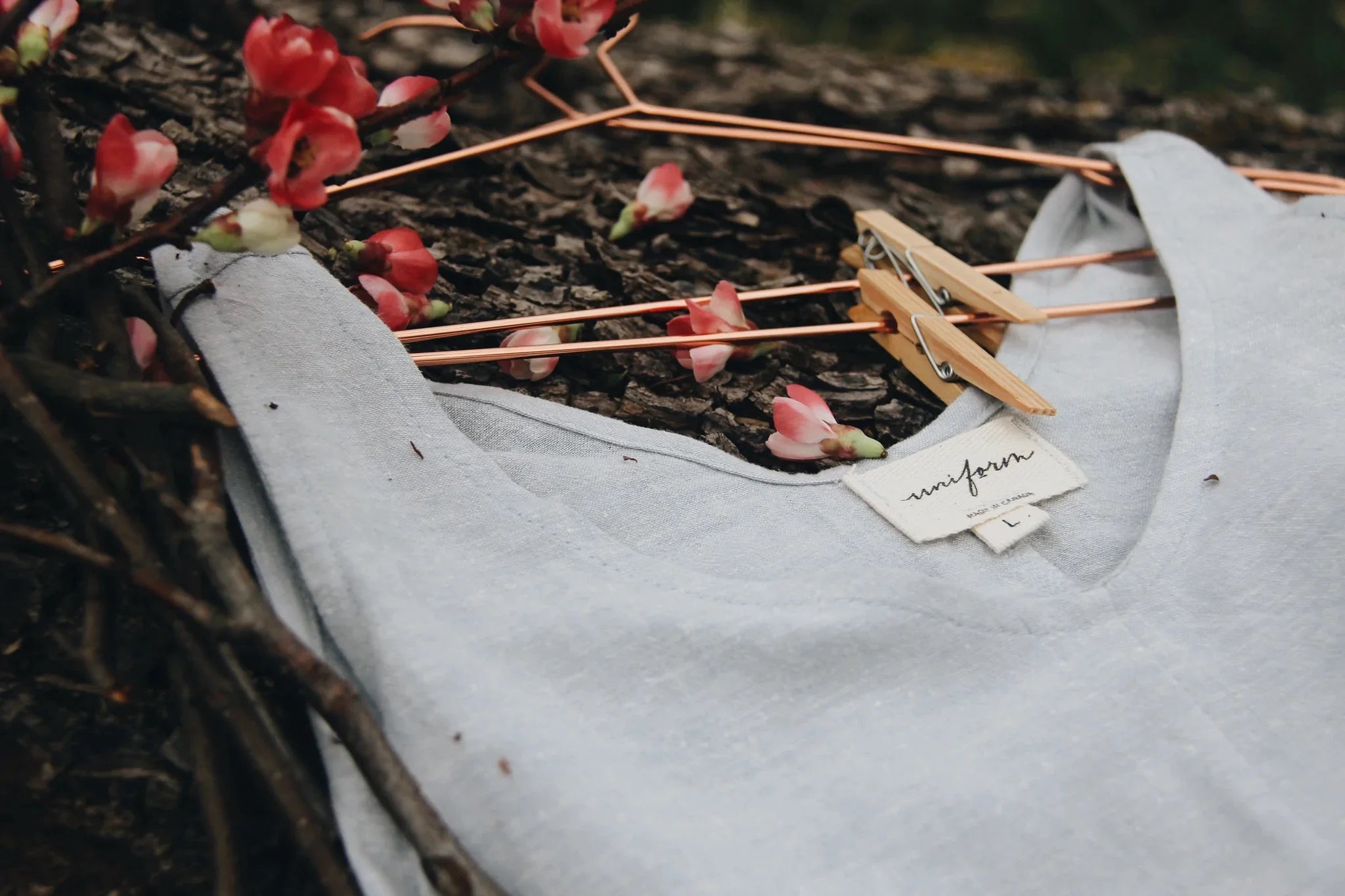 A linen top on a hanger lays on a natural grass
surface
