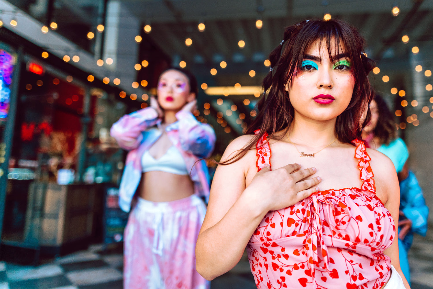 Two women dressed in vibrant clothing and makeup inside a retail
store