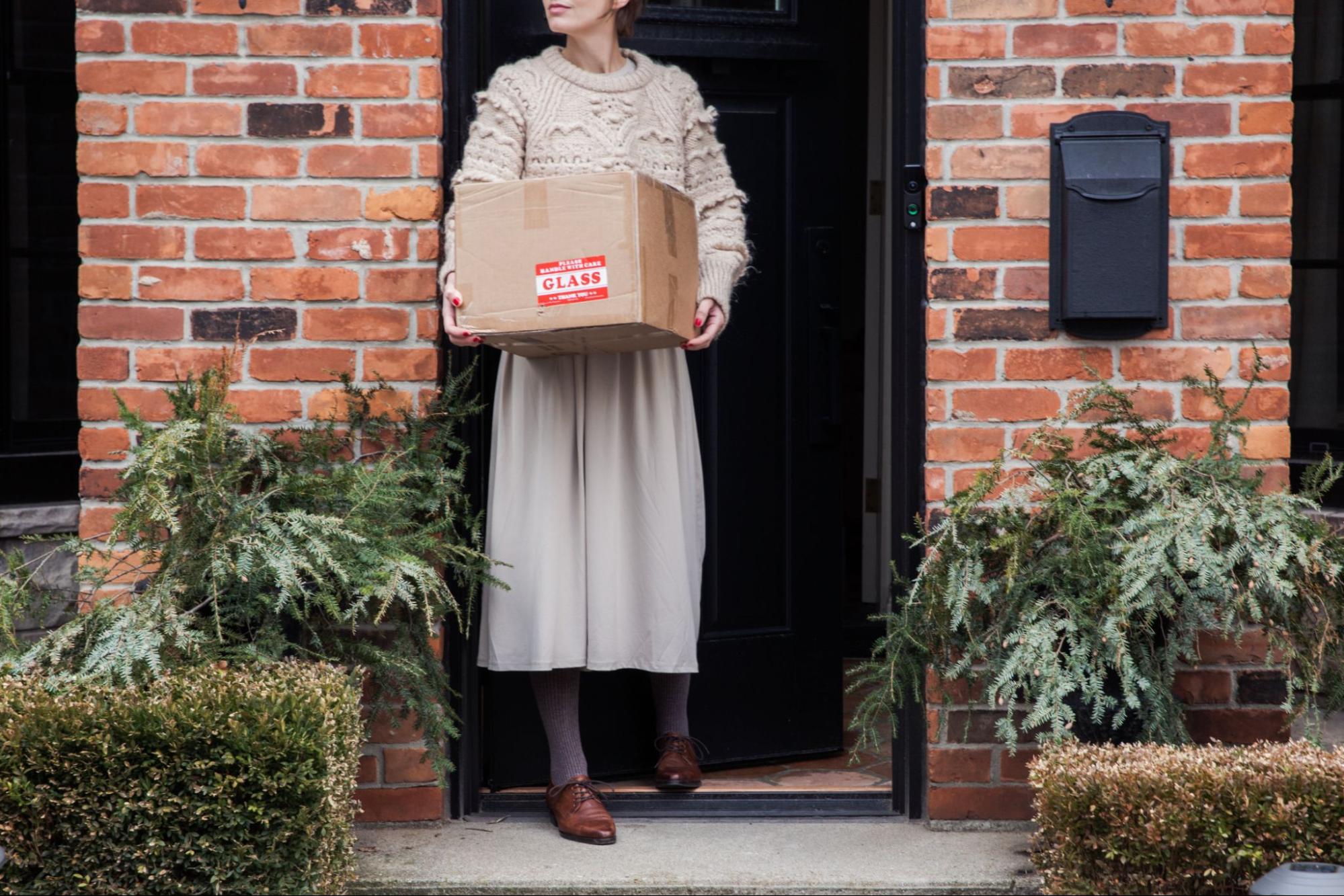 A woman thanks the postal carrier who delivered her package before heading
inside her home.