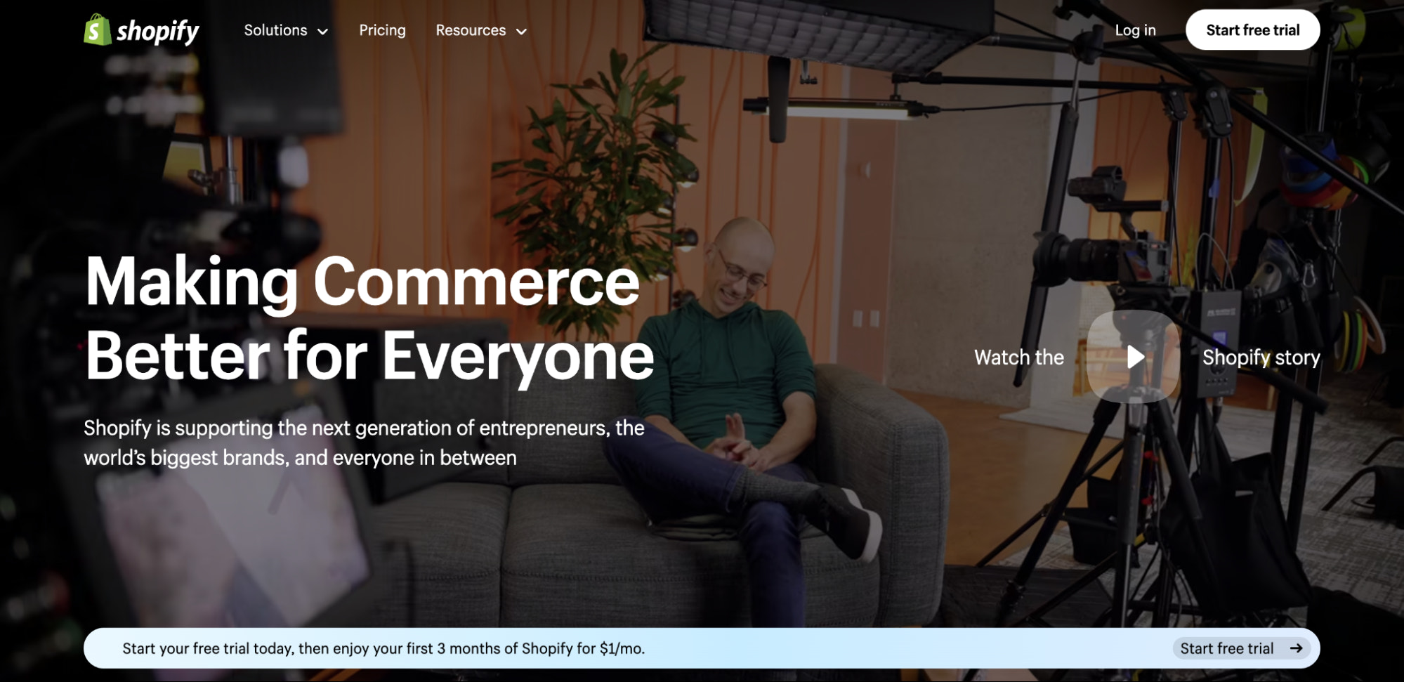 Shopify 徽标和导航栏位于 Shopify 创始人 Tobi Lütke 坐在灰色沙发上的视频上方。