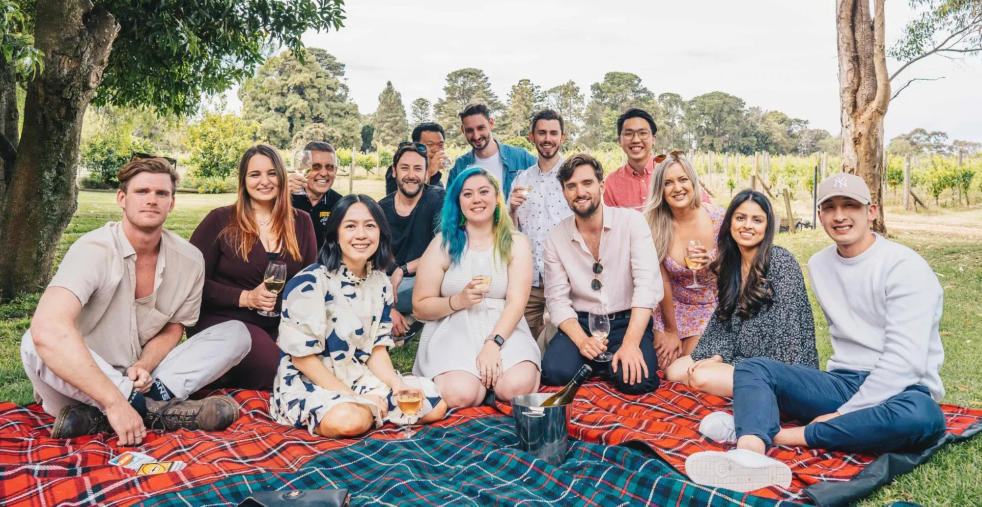 Exo Digital 团队坐在葡萄园的野餐地毯上拍照。
