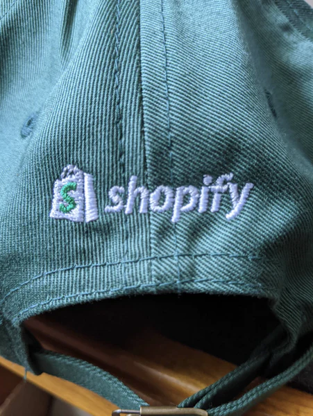 绿色 Shopify 球帽，带白色刺绣徽标和名称